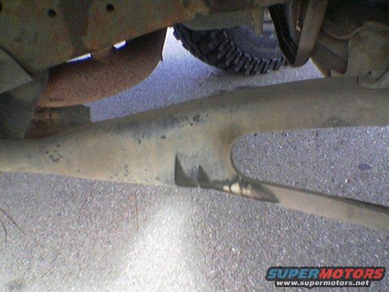 Underside of a vehicle showing suspension components and exhaust pipe
