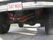 1994 Ford Bronco - Close-up view of the rear axle and suspension of a 1994 Ford Bronco, showing modified red springs and shocks.