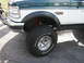 1994 Ford Bronco - Close-up of a 1994 Ford Bronco's front fender and wheel, showing off its off-road tires.