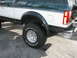 1994 Ford Bronco - Close-up of the rear wheel and fender of a two-tone Ford Bronco.