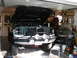 1994 Ford Bronco - Front view of a 1994 Ford Bronco in a garage, hood open, with an aftermarket bumper and auxiliary lights.