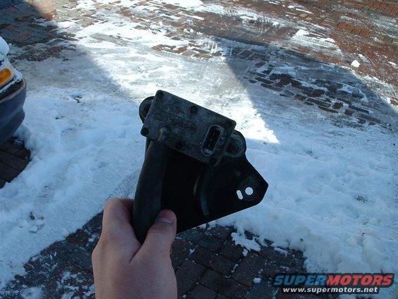 Engine part held in hand with snow and brick ground