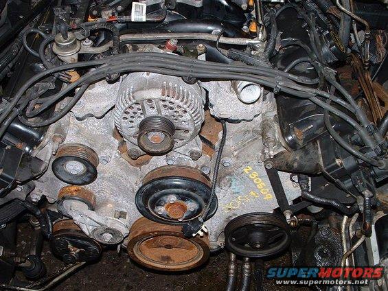 1996 Ford Crown Victoria engine bay with alternator and pulleys visible. Yellow markings on engine block