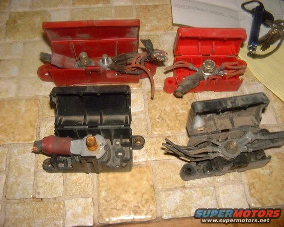 Four battery cable connectors, two red and two black, on a tiled surface