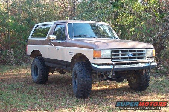 Brown and tan lifted 1987 Ford Bronco parked outdoors