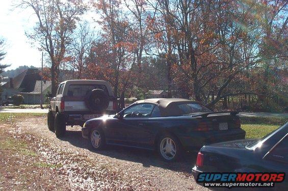 1994 Ford Mustang convertible parked next to a Ford Bronco