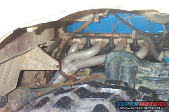 Engine with silver headers and blue valve cover, close-up view
