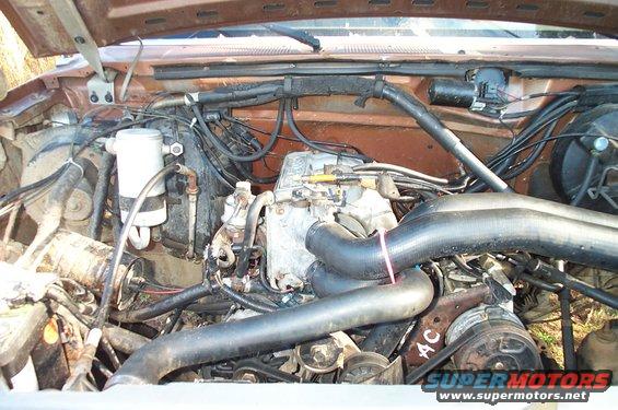 Engine bay with headers and visible 'AC' marking