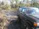 1988 Ford Bronco - Black 1988 Ford Bronco navigating a wet, muddy off-road path.