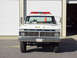 1973 Ford F-250 - This 1973 Ford F-250 fire truck, marked "SQUAD - 111", is seen from the front with its emergency lights on.