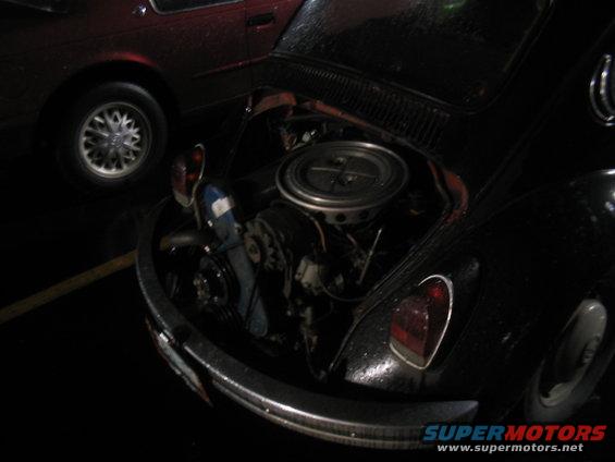 Black Volkswagen Beetle engine bay with exposed engine and air filter