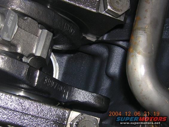 Close-up of engine block casting with part number 3907881 and exhaust pipe