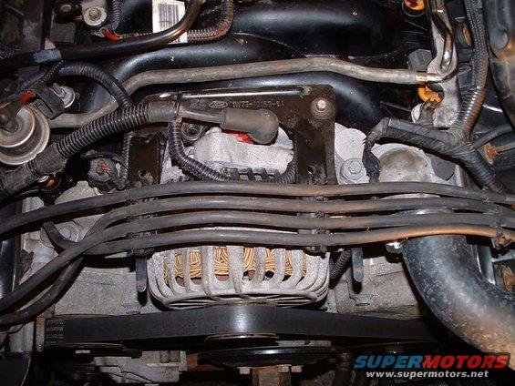 Engine bay with alternator, belts, and wiring visible