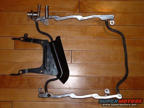 Ford fuel rail assembly with hoses and mounting bracket. Text on bracket reads 'Ford'