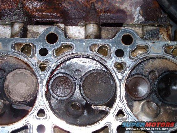 Engine cylinder head with carbon buildup on valves and combustion chambers
