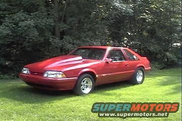 Red 1990 Ford Mustang with a cowl induction hood parked on grass