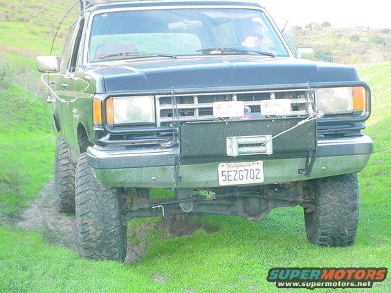1987 Ford Bronco front view with winch and off-road tires on grassy terrain