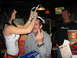 2002 Ford Taurus - A man is playfully given a foil crown while giving the middle finger in a bar setting.