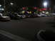 2002 Ford Taurus - Cars parked in a lot at night in front of a strip mall with lights on.