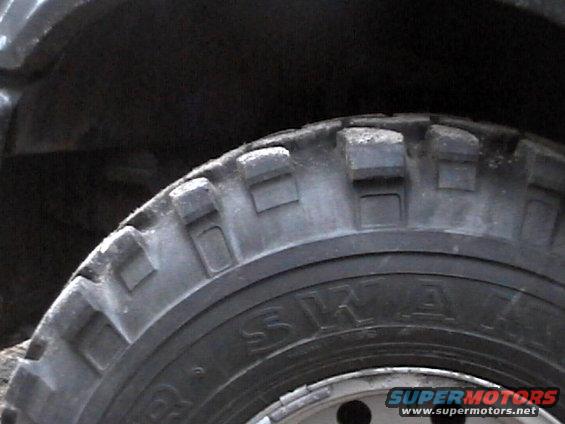 Close-up of a knobby off-road tire with visible text