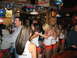 2002 Ford Taurus - A group of people are gathered in a bar, with several waitresses in uniform visible.