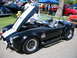 2002 Ford Taurus - A black AC Cobra replica is displayed with its hood open at an outdoor car show.