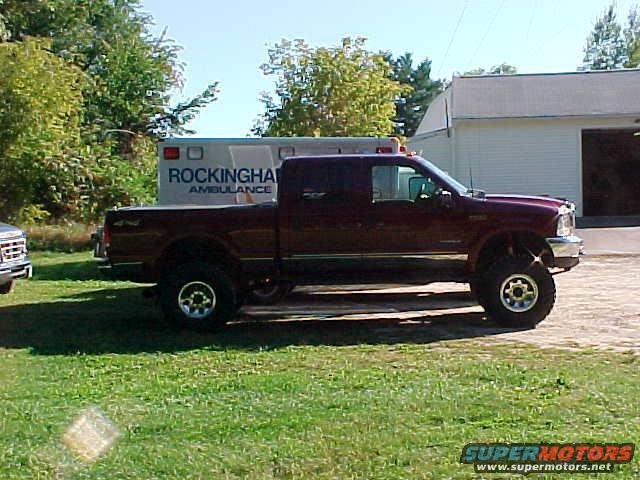 Maroon Ford F-250 pickup truck parked next to an ambulance