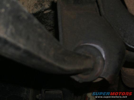 Close-up of a metal suspension part with a rubber bushing