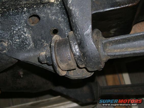 Close-up of a rusty suspension bushing and metal bracket