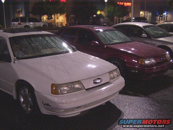 White sedan with a sunroof, front view, in the rain