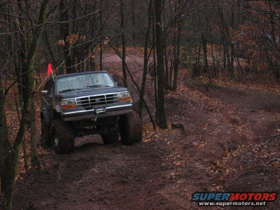1995 Ford Bronco on a muddy trail with large tires