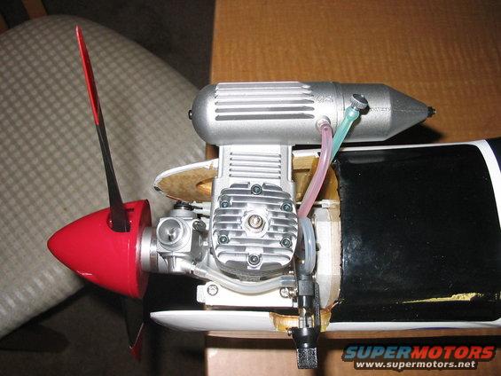Model airplane engine with red propeller and silver exhaust