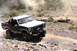 1984 Ford Bronco - This Ford Bronco is kicking up dust as it navigates a rough, outdoor landscape.