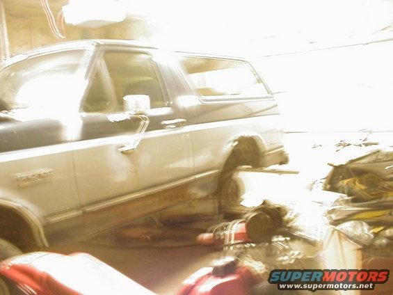 Side view of a two-tone 1987 Ford Bronco with rust on the lower body