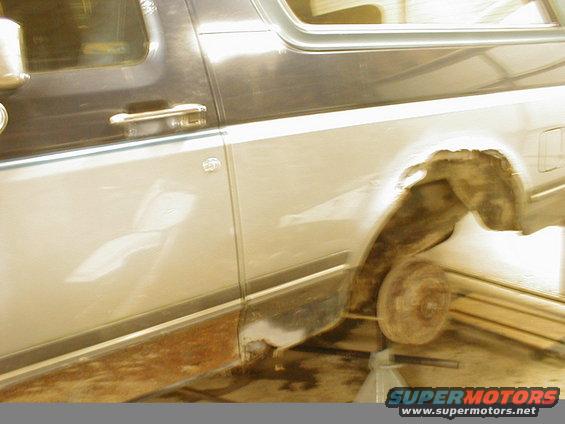1987 Ford Bronco side view showing rusted wheel well and body damage