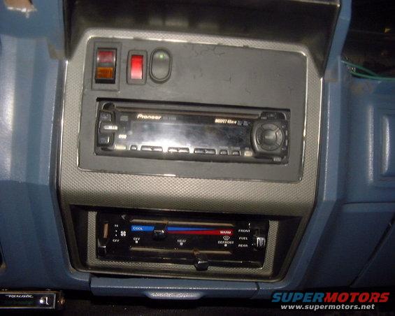 Car dashboard showing a Pioneer stereo and climate controls. Blue interior panels are visible