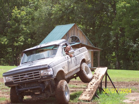 Gray Ford F-Series truck with front wheel off the ground on a wooden ramp