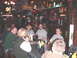 1984 Ford Bronco - A group of people are seated at tables inside a bar decorated with sports memorabilia.