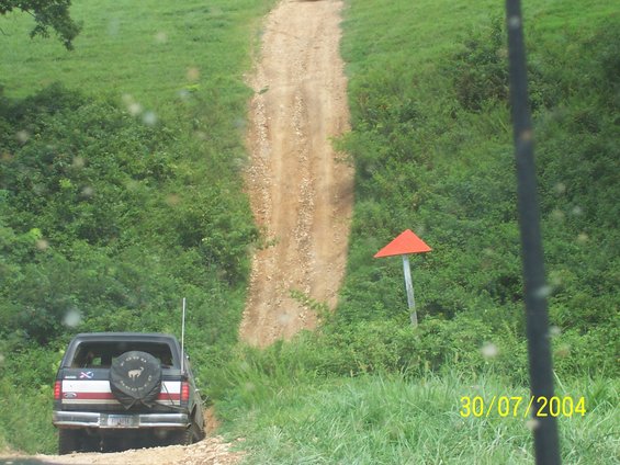 Black Ford Bronco with spare tire on rear, driving on a dirt road