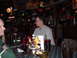 1984 Ford Bronco - People are seated at a table in a dimly lit bar, with drinks and condiments visible.