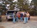 1984 Ford Bronco - Several men are conversing outdoors near two Ford trucks, one with its hood open.