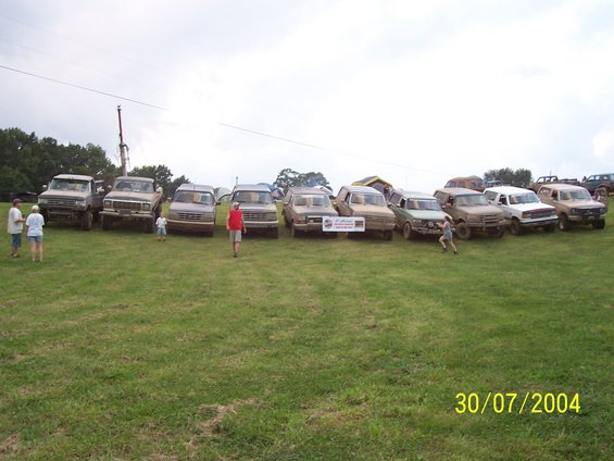 Line of trucks and SUVs parked in a field with a date stamp of 30/07/2004