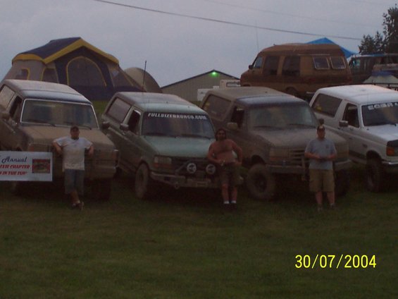 Tan 1992 Ford Bronco with a camper shell, parked on grass