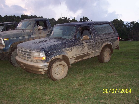 Mud-covered dark blue SUV, 3/4 front view