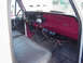 1973 Ford F-250 - The interior of a vintage Ford truck features a maroon dashboard and a dark gray bench seat.