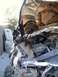 1979 Ford Bronco - The severely damaged engine compartment of a white vehicle, showing extensive damage from a rollover incident.
