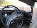 1979 Ford Bronco - Interior view of a 1979 Ford Bronco, showing a damaged dashboard and steering wheel, with the driver's side door open.