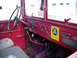 1973 Ford F-250 - Interior view of a red truck's dashboard, showing the steering wheel, gauges, and various controls.