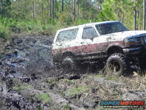 1993 Ford Bronco splashing mud while off-roading