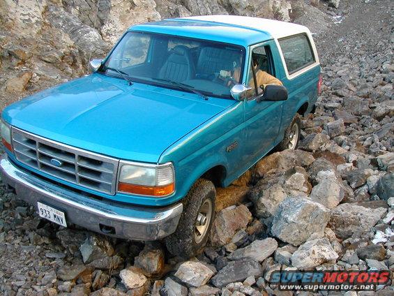 Blue 1994 Ford Bronco navigating a rocky trail